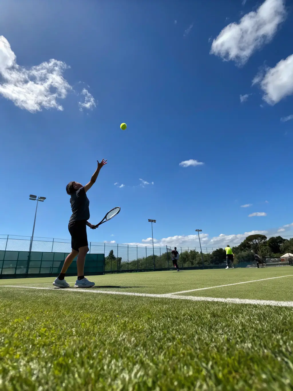A vibrant image of tennis players in action during a training session at TPCP TENNIS PADEL CLUB PUILBOREAU, showcasing the energy and skill development in the tennis program.