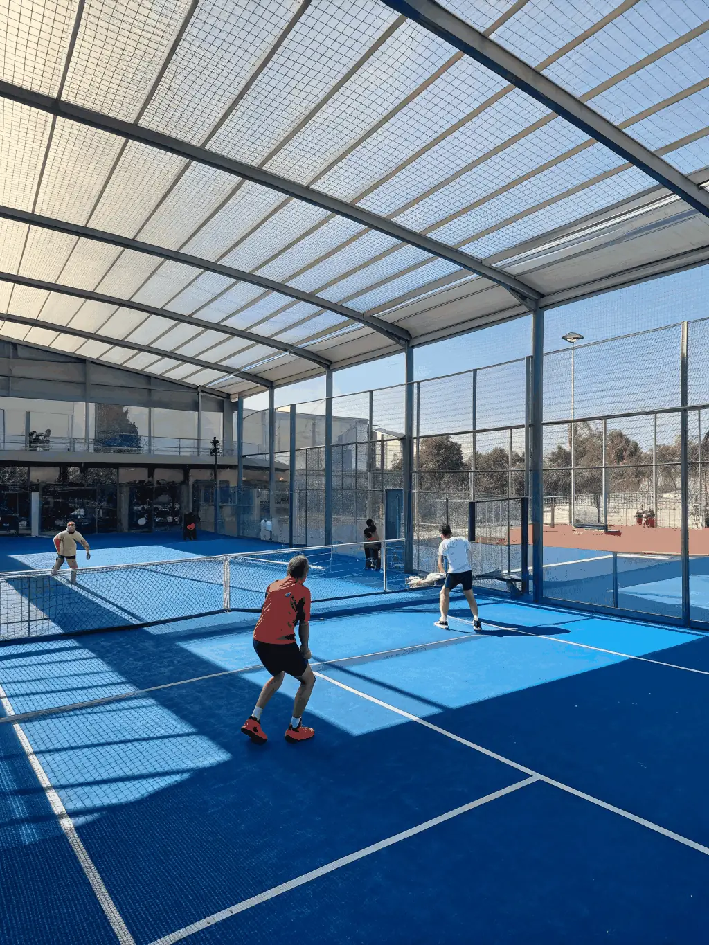 An energetic image of players rallying on a padel court, emphasizing teamwork and enjoyment.